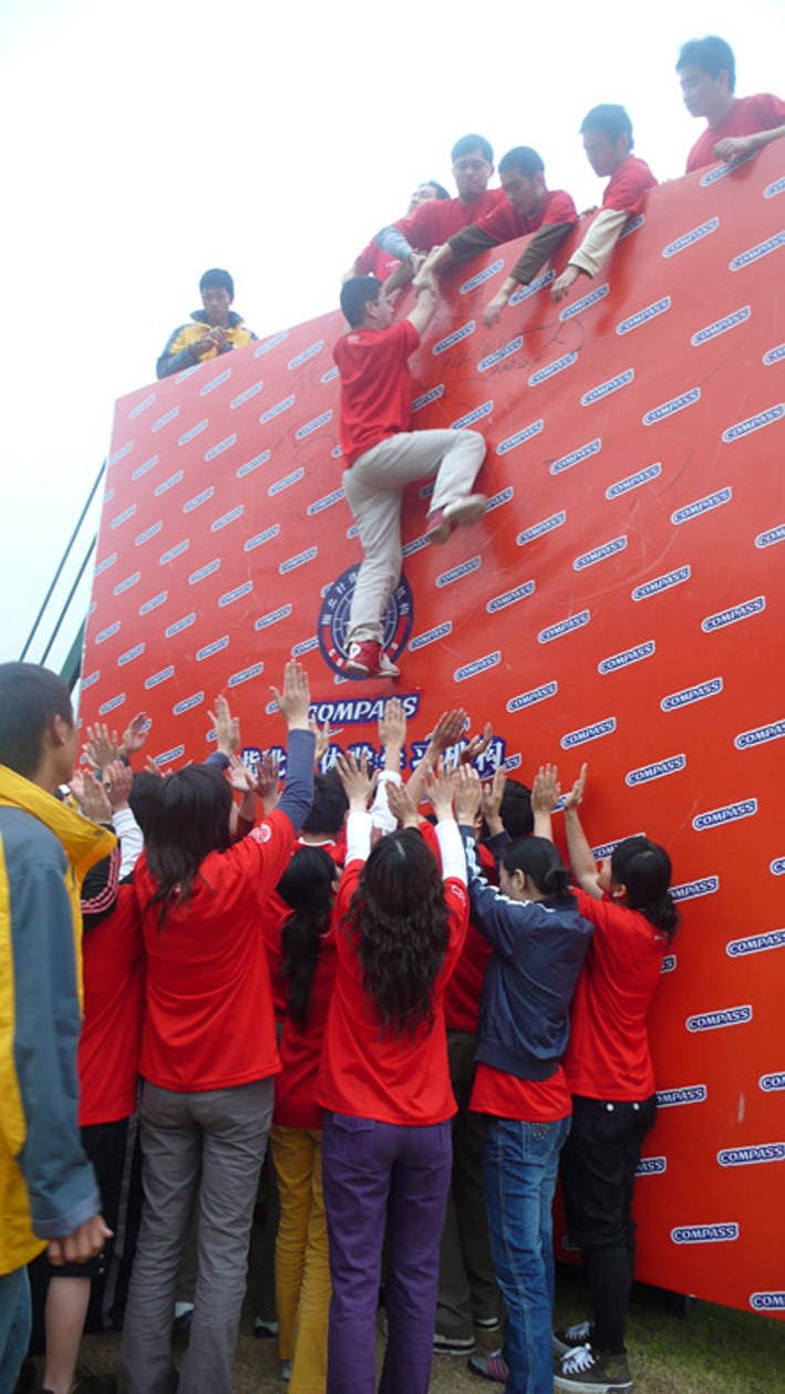 Everybody works cooperatively to cross high wall of 4 meters so as to graduate. 